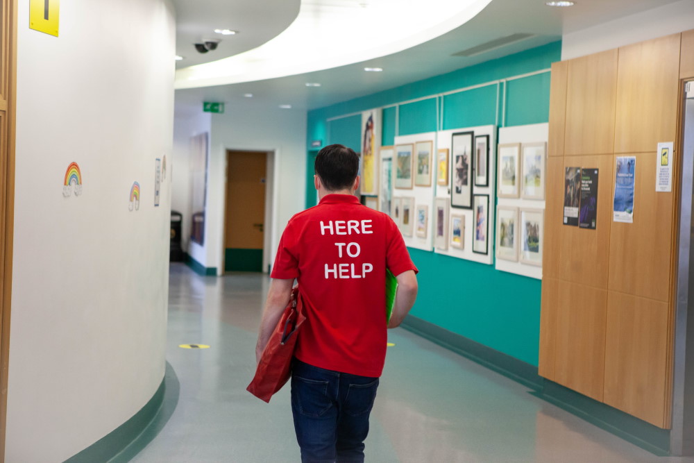 Photograph of a volunteer walking through the hospital